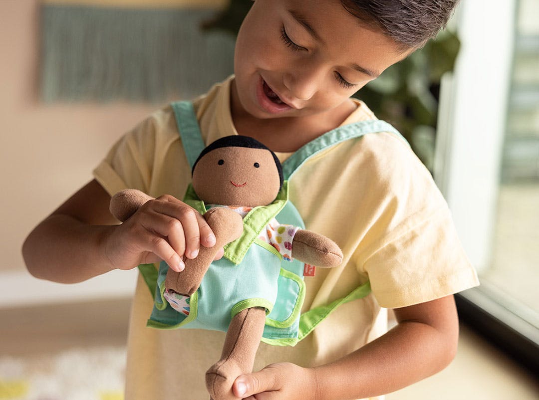 boy wearing accessories with baby doll