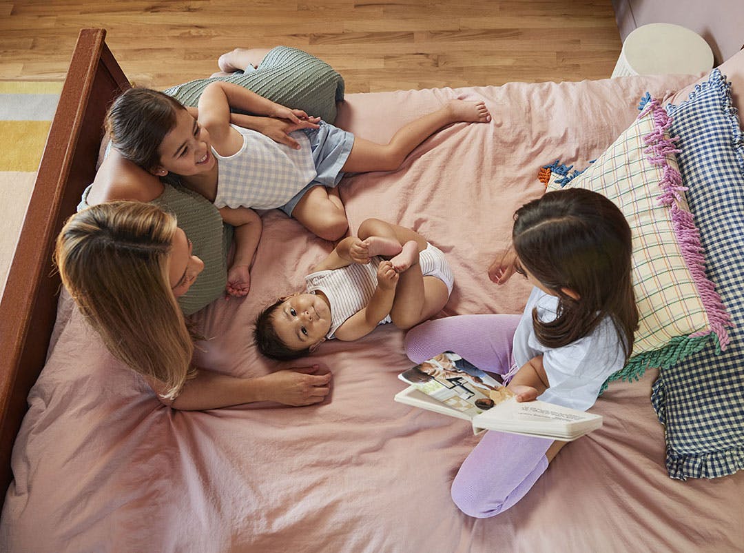 family reading book on bed