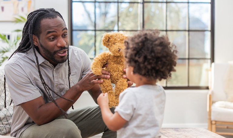 Father giving a teddy bear to their child