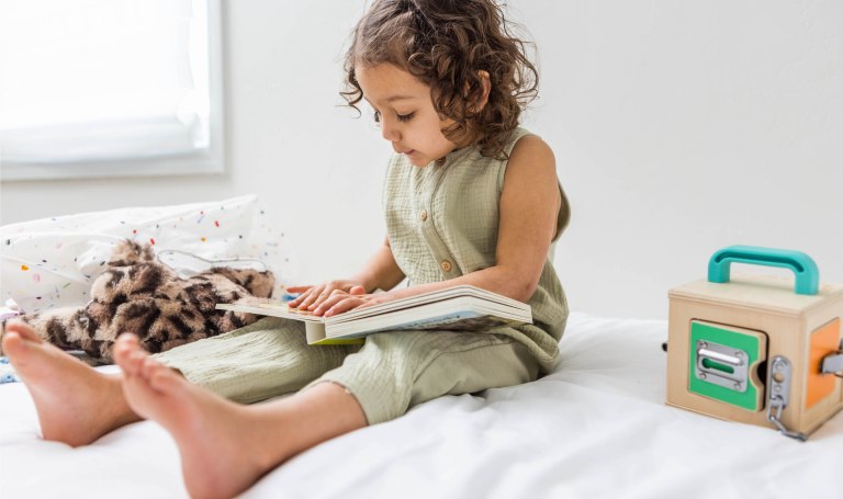 Toddler looking at a Lovevery book