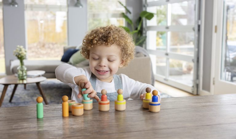 Toddler playing with the Lovevery Peg People