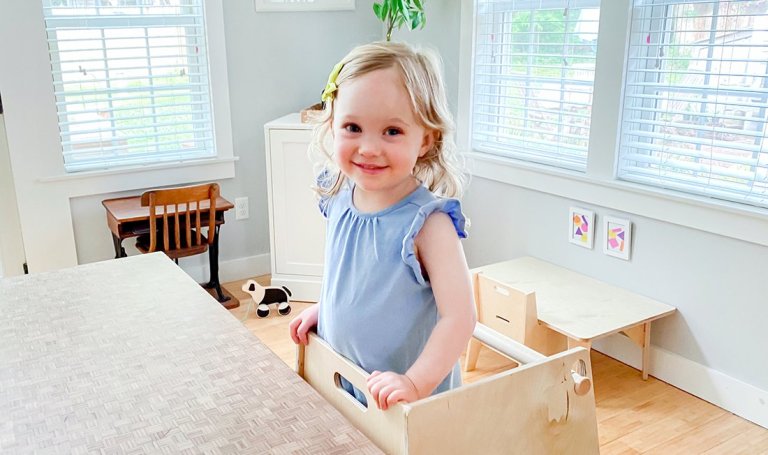 Toddler standing on a stool to get to the kitchen counter