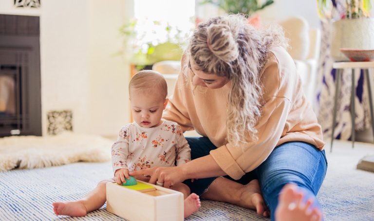 Mother and baby playing with the Ball Drop Box by Lovevery