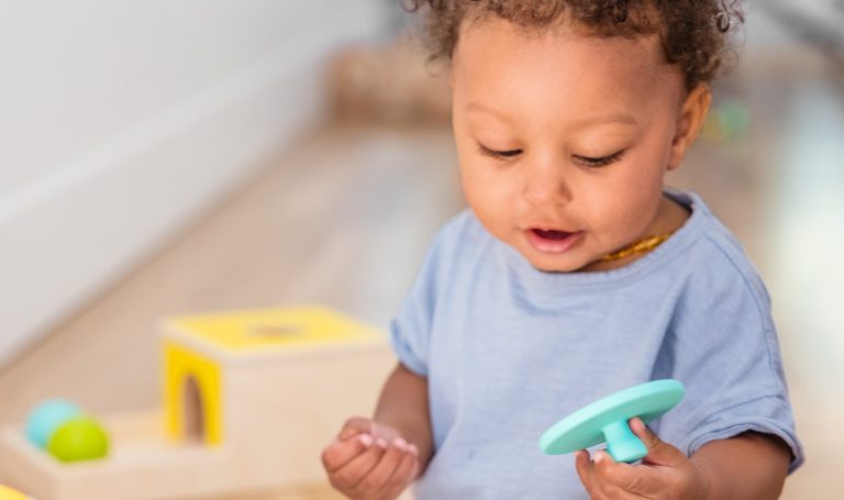 Baby playing with a Lovevery puzzle