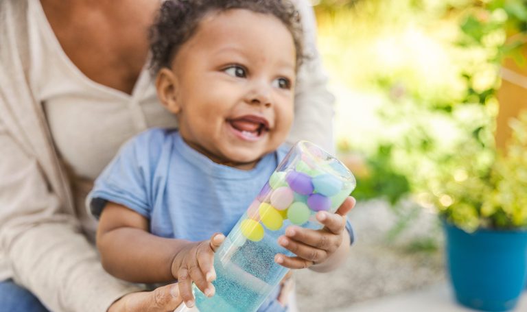 Baby holding a sensory bottle