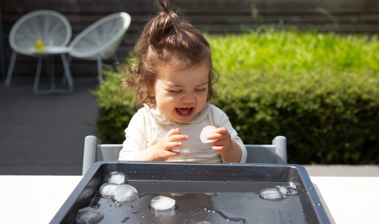 Toddler playing with ice cubes
