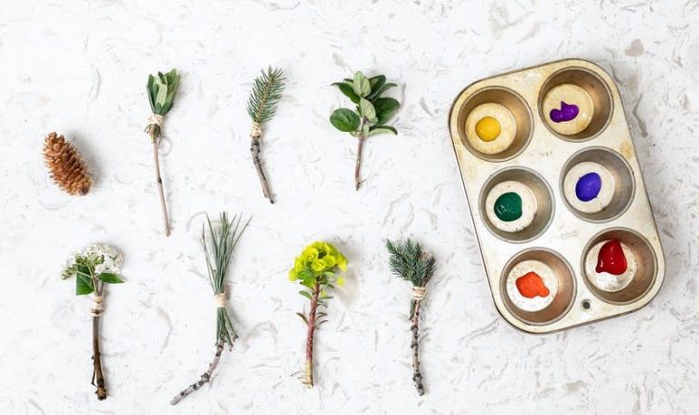 Muffin tin with paint in each section along with different plants to use as paint brushes