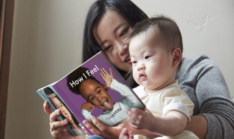 Mother and baby reading a book together