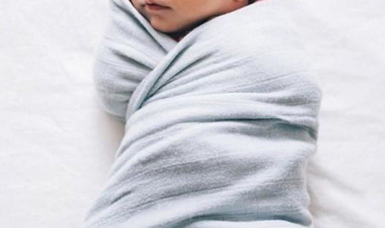 Baby wrapped in a blue swaddle