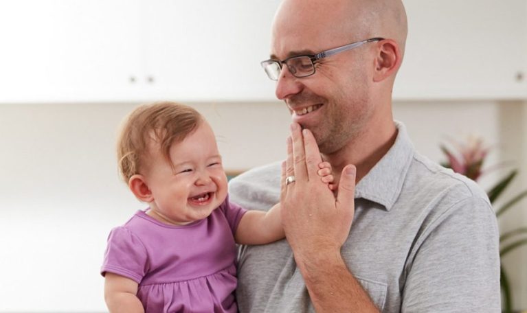 A father uses sign language with his baby.