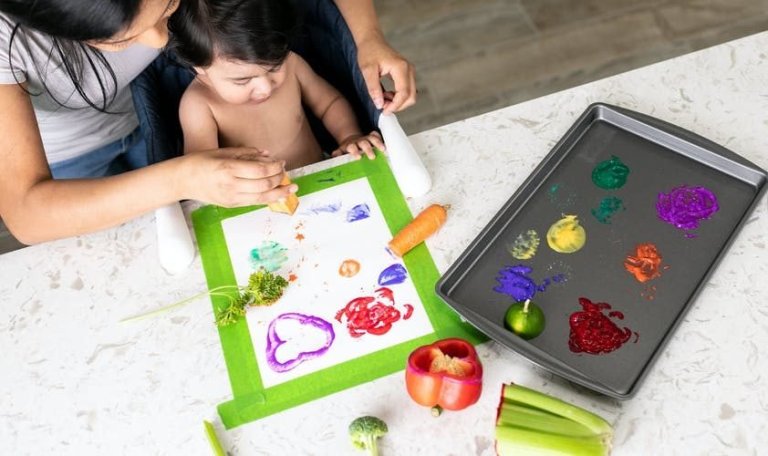 Baby painting with different kinds of vegetables