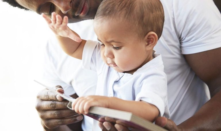 Baby and man looking at a book together