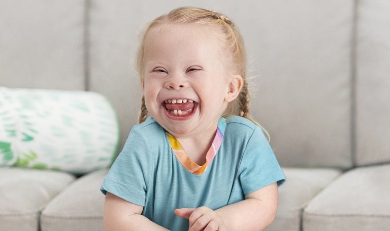 Toddler in a blue shirt smiling and laughing