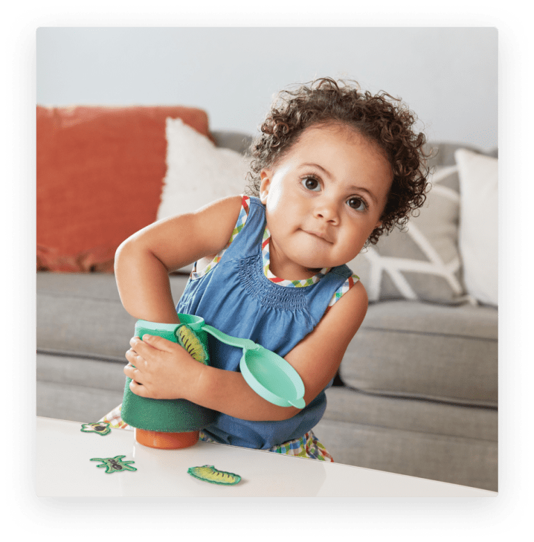 Toddler playing with the Fuzzy Bug Shrub by Lovevery